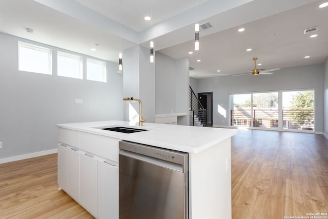 kitchen with light wood finished floors, visible vents, a center island with sink, stainless steel dishwasher, and a sink