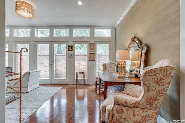 interior space with french doors, wood finished floors, and crown molding