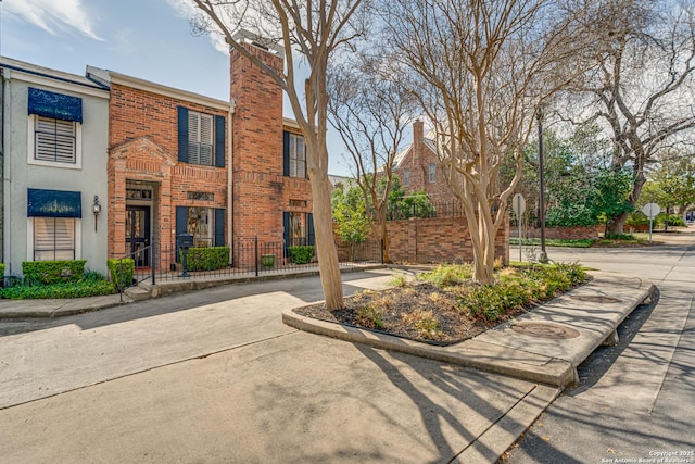 view of front of property featuring brick siding and a chimney