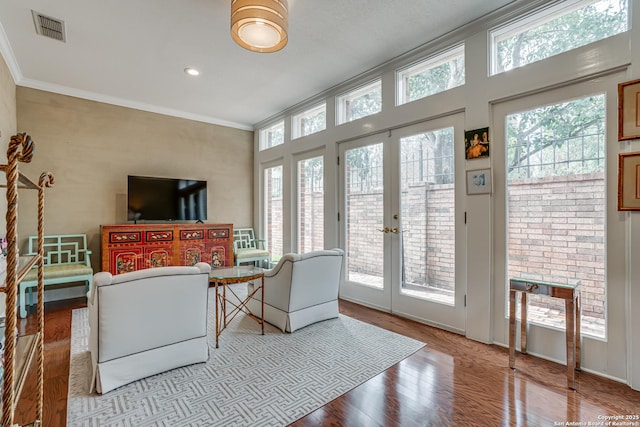 living area featuring visible vents, plenty of natural light, crown molding, and french doors