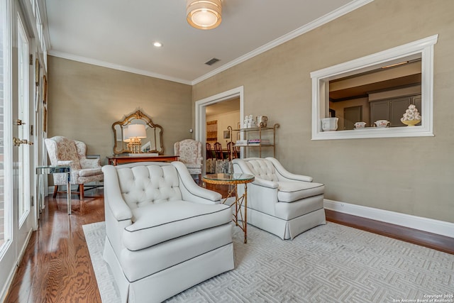sitting room with visible vents, wood finished floors, recessed lighting, crown molding, and baseboards