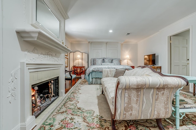 bedroom featuring a tiled fireplace, recessed lighting, and ornamental molding