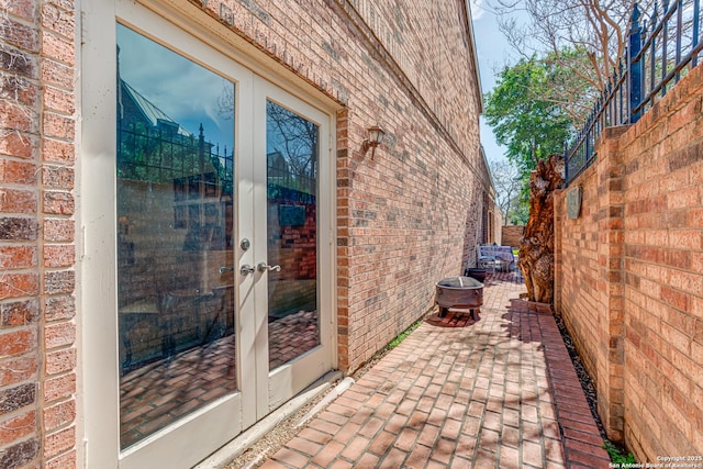 doorway to property with brick siding, french doors, and a patio