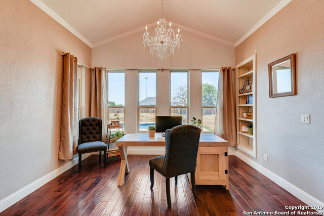 home office with baseboards, a chandelier, dark wood-style flooring, and crown molding