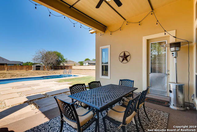 view of patio with outdoor dining space, a fenced in pool, a fenced backyard, and ceiling fan