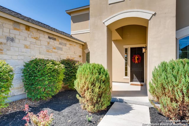 property entrance with stone siding and stucco siding