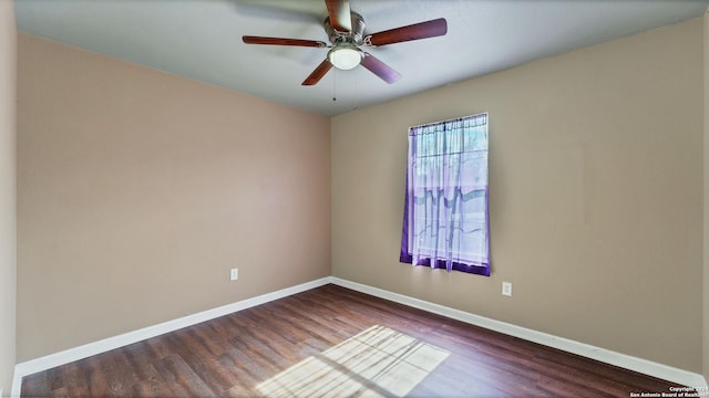 spare room featuring dark wood finished floors, baseboards, and ceiling fan