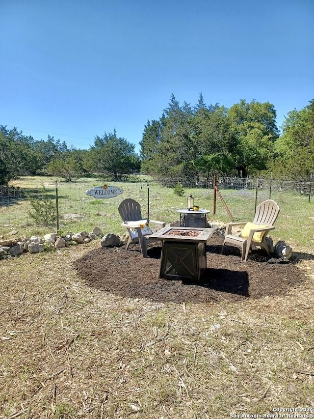 view of yard featuring an outdoor fire pit and fence