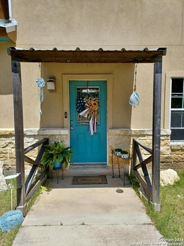 property entrance with stone siding and stucco siding