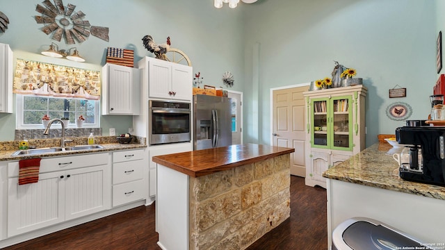 kitchen featuring a sink, dark wood-type flooring, white cabinets, and stainless steel appliances