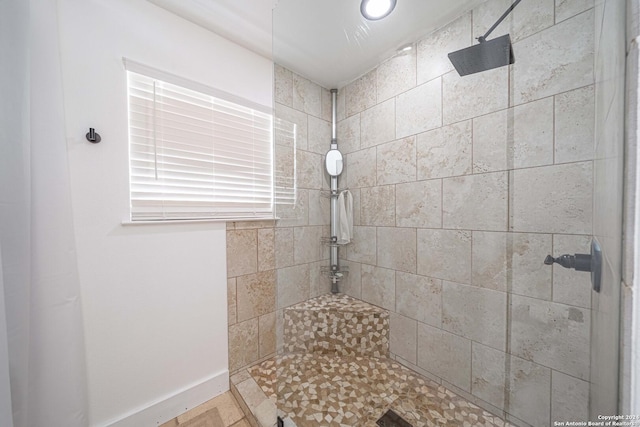 bathroom featuring baseboards and tiled shower