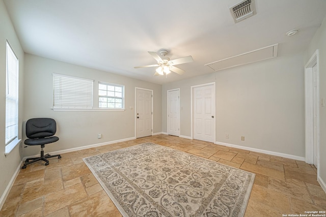 interior space featuring visible vents, baseboards, attic access, and stone tile floors