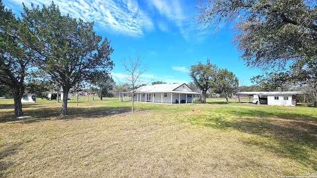 view of yard with a carport and an outdoor structure