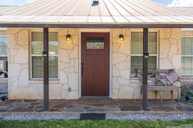 property entrance featuring stone siding, metal roof, and a standing seam roof