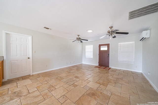 entryway with a wall mounted air conditioner, visible vents, baseboards, and stone tile flooring