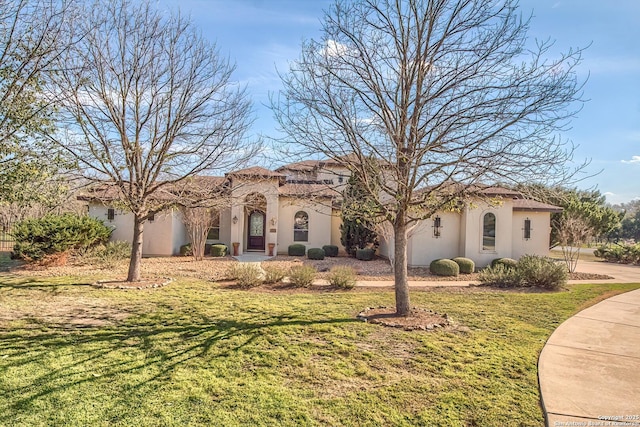 mediterranean / spanish-style home featuring stucco siding and a front lawn