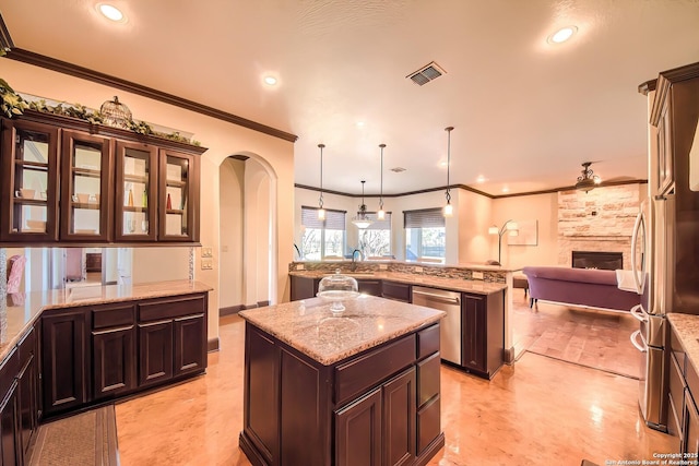 kitchen featuring a kitchen island, crown molding, open floor plan, dishwasher, and arched walkways