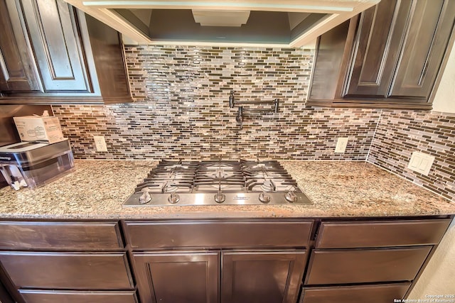 kitchen featuring tasteful backsplash, dark brown cabinets, and stainless steel gas stovetop