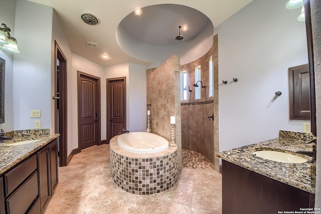 full bathroom with two vanities, walk in shower, a bath, and a sink