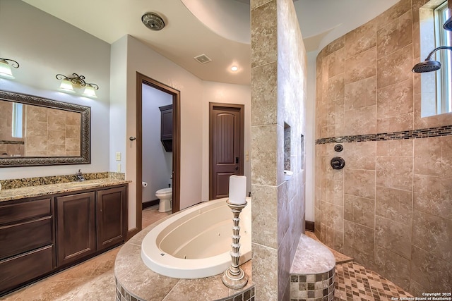 bathroom featuring vanity, visible vents, a walk in shower, a jetted tub, and toilet