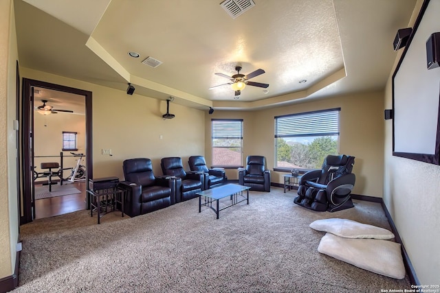 interior space featuring a ceiling fan, a tray ceiling, baseboards, and visible vents