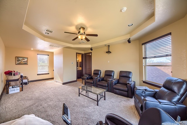 cinema with a raised ceiling, visible vents, baseboards, and light carpet