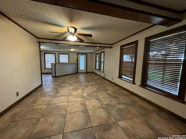 spare room featuring tile patterned flooring, crown molding, baseboards, a textured ceiling, and a ceiling fan