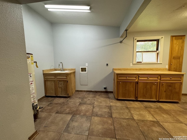 laundry area featuring hookup for a washing machine, baseboards, hookup for an electric dryer, cabinet space, and a sink