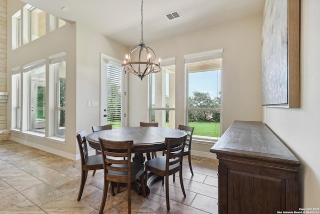 dining area with a wealth of natural light, visible vents, baseboards, and a notable chandelier