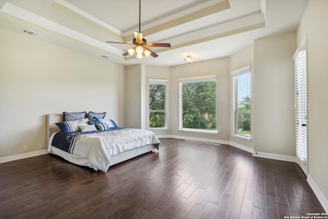 bedroom featuring dark wood finished floors, visible vents, a raised ceiling, and baseboards