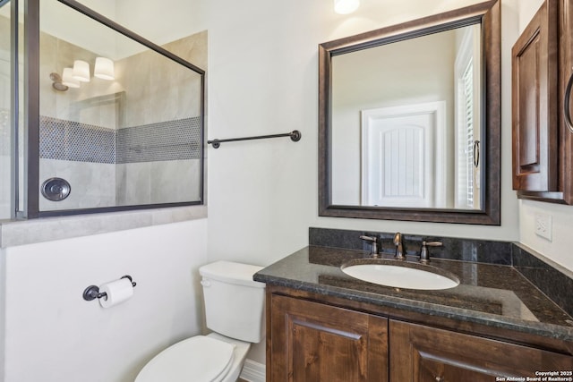 bathroom featuring tiled shower, toilet, and vanity