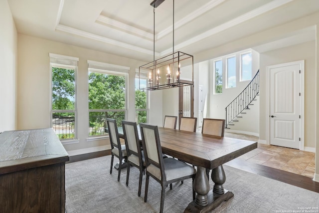 dining room with stairs, a tray ceiling, a wealth of natural light, and a chandelier