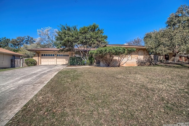 ranch-style home featuring concrete driveway, brick siding, and a front lawn