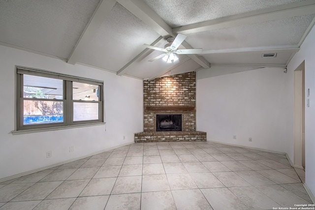 unfurnished living room with lofted ceiling with beams, a textured ceiling, light tile patterned flooring, a brick fireplace, and ceiling fan