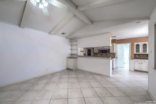 kitchen featuring visible vents, a peninsula, ceiling fan, decorative backsplash, and stainless steel appliances