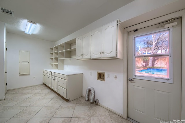 laundry room featuring hookup for a washing machine, light tile patterned floors, cabinet space, and visible vents