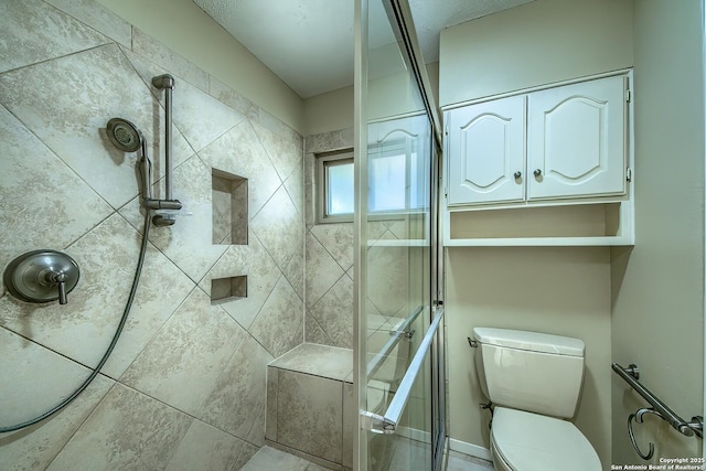 bathroom featuring toilet and a stall shower