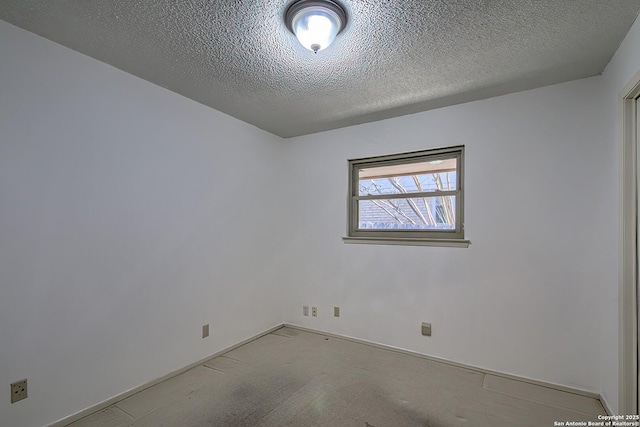 carpeted empty room featuring baseboards and a textured ceiling