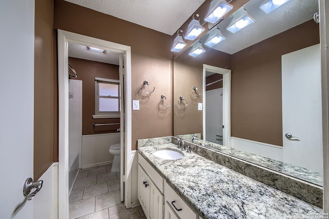 bathroom featuring vanity, shower / bathing tub combination, toilet, and a textured ceiling