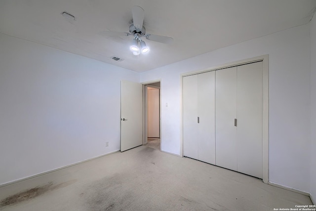 unfurnished bedroom with visible vents, light colored carpet, a closet, and ceiling fan