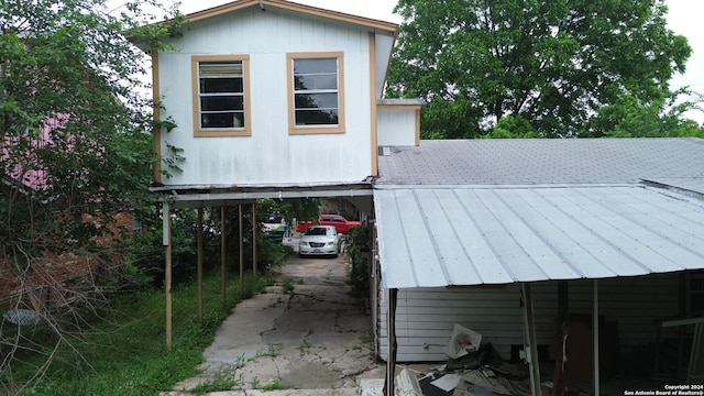 view of side of property with a carport and metal roof