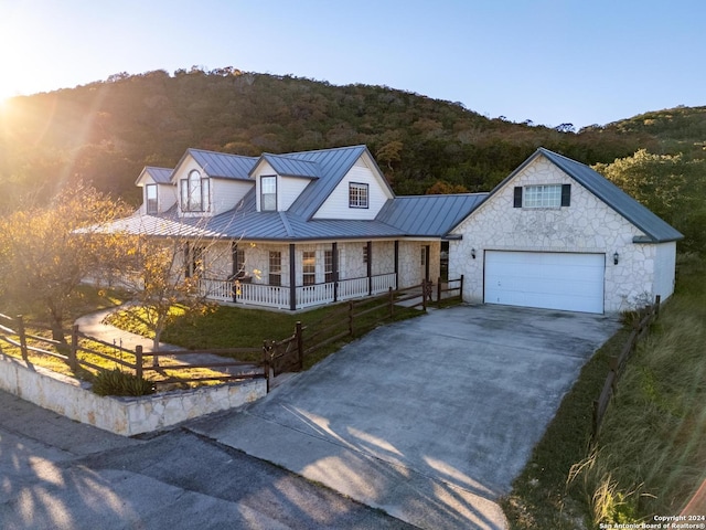 view of front of house featuring a standing seam roof, fence, stone siding, and metal roof