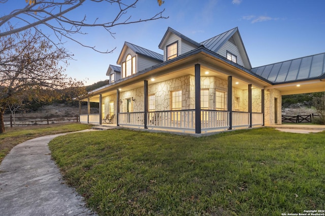 exterior space with metal roof, stone siding, a yard, and a standing seam roof