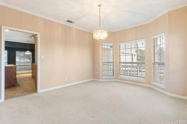 spare room featuring visible vents, plenty of natural light, carpet, crown molding, and a chandelier