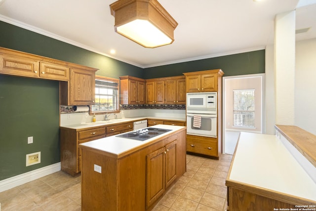 kitchen featuring a sink, a kitchen island, white appliances, brown cabinetry, and crown molding