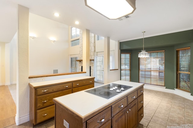 kitchen with visible vents, brown cabinets, a kitchen island, and black electric stovetop