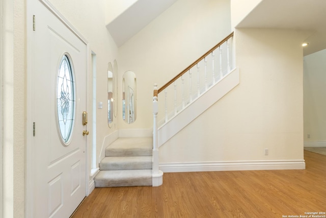 foyer featuring stairway, wood finished floors, and baseboards