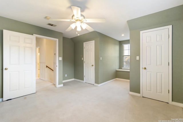 unfurnished bedroom with visible vents, light carpet, baseboards, and ceiling fan