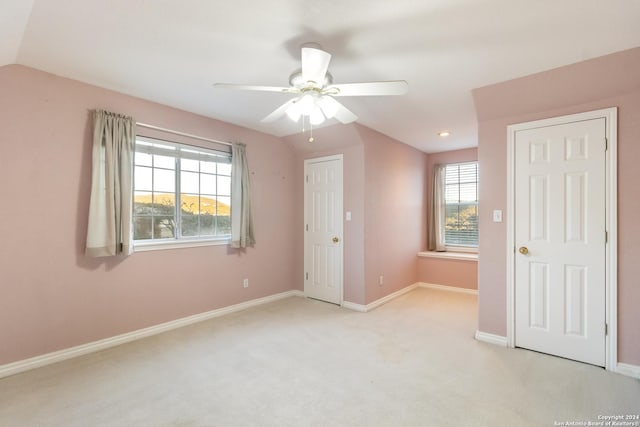 spare room with carpet flooring, a ceiling fan, baseboards, and vaulted ceiling