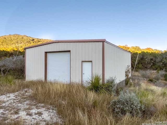 view of outbuilding featuring a mountain view and an outdoor structure